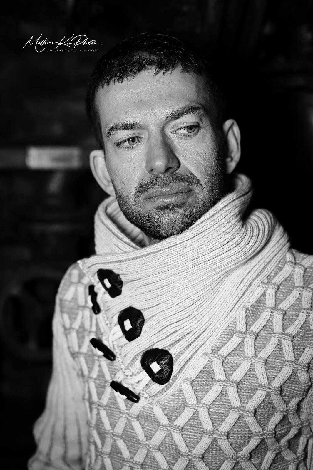 Schwarz-Weiß-Portrait eines Mannes im markanten Strickpullover
